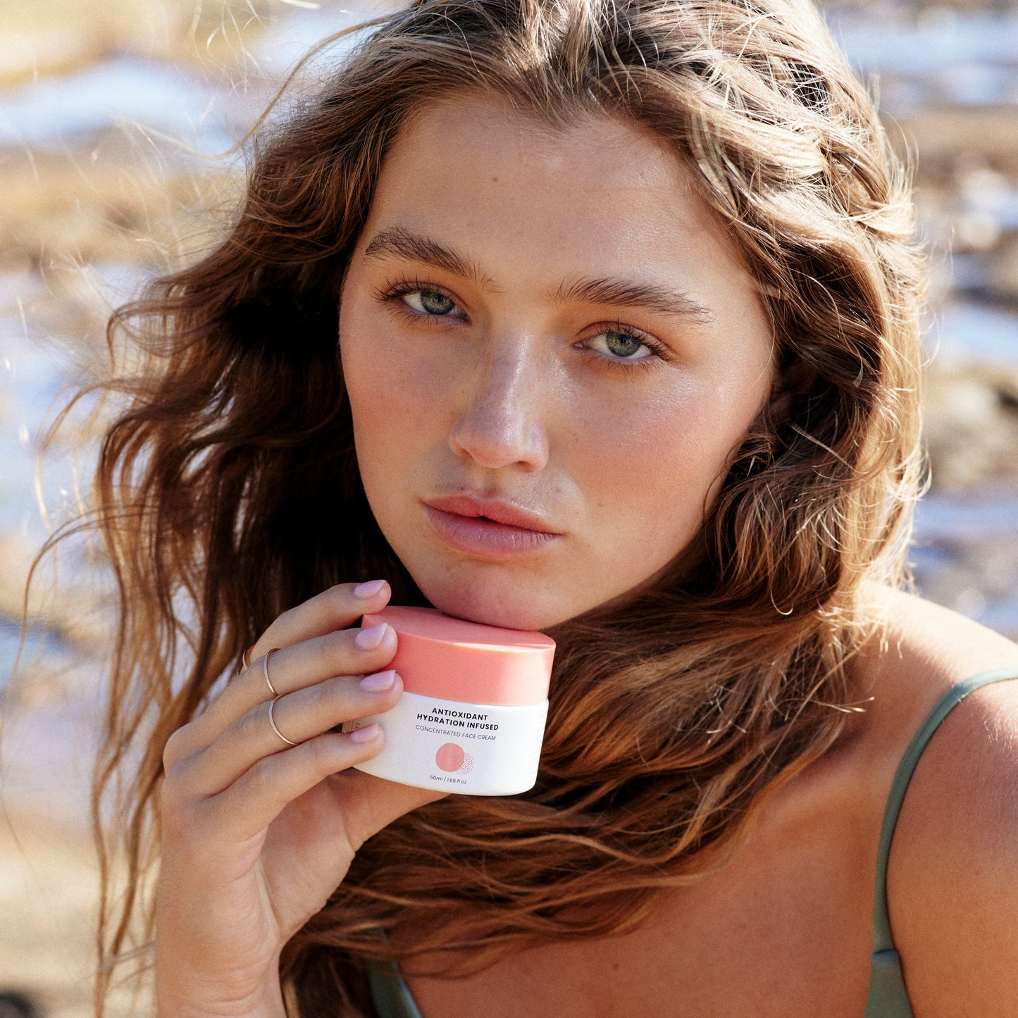 Hub for Belle Antioxidant hydration infused moisturiser containing Waratah flower, Kakadu Plum, Vitamin E and Jojoba jar being held under models chin