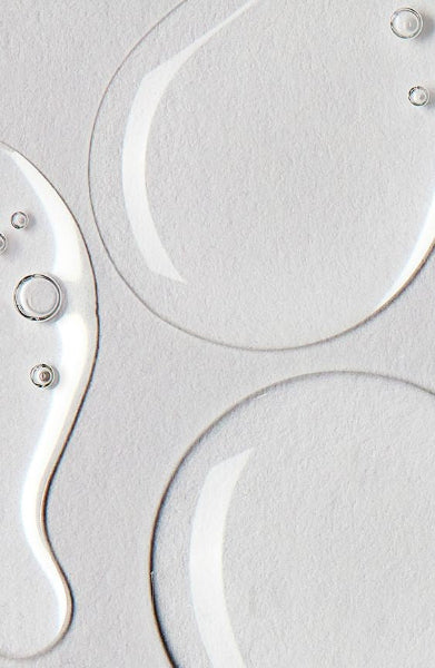 Close-up of metallic Hyaluronic on a textured gray surface