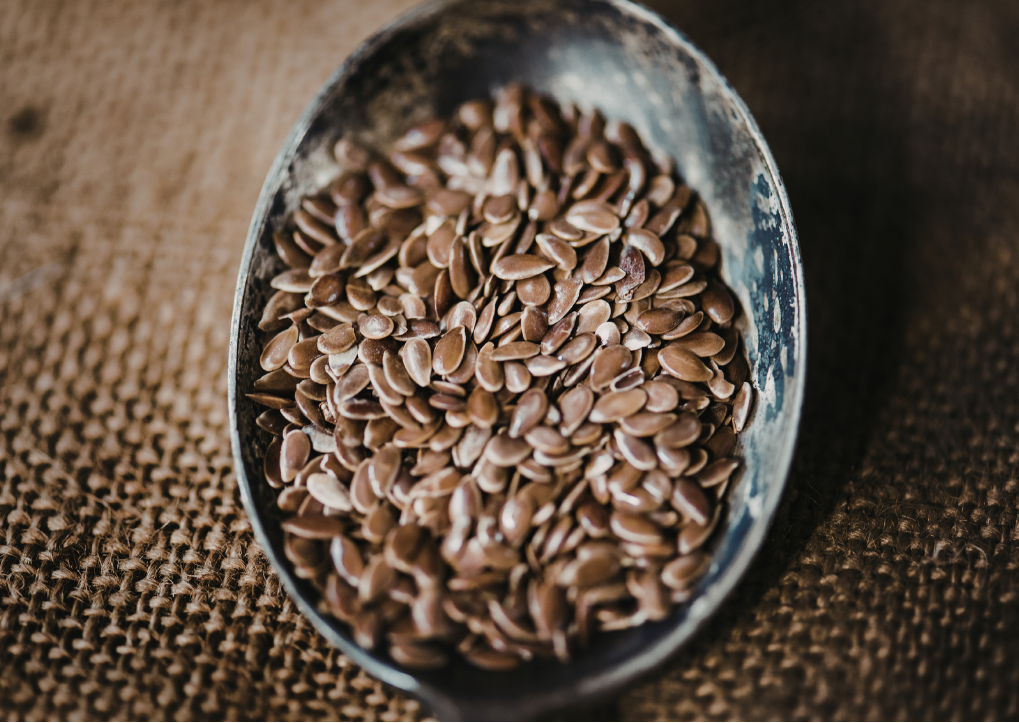 Bowl filled with flax seeds on a textured surface