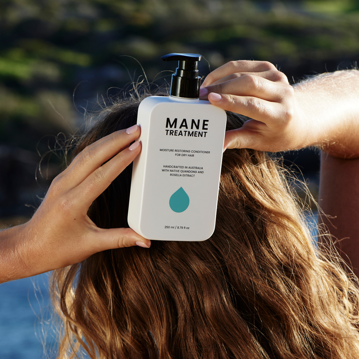Mane Treatment moisture restoring, hair growth promoting conditioner front view held by women against the back of her hair by Hub for Belle